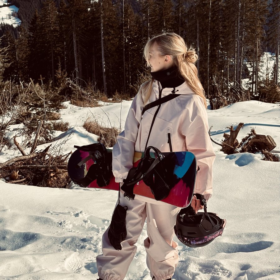 Catharina mit Snowboard im Schnee vor verschneiten Bergen